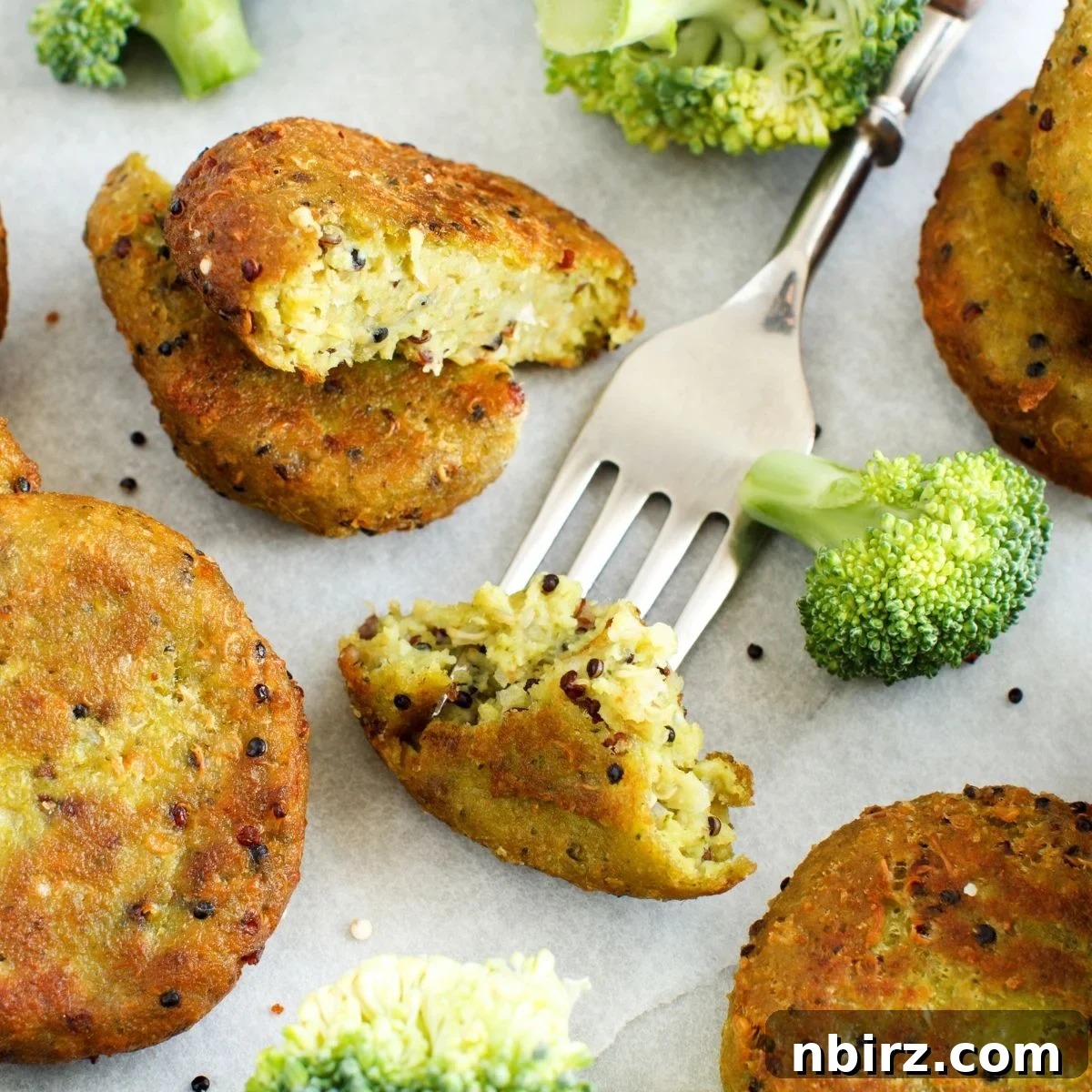 Nourishing Broccoli Quinoa Protein Patties 4 Several golden-brown baked broccoli quinoa protein cakes beautifully arranged on parchment paper, waiting to be savored.