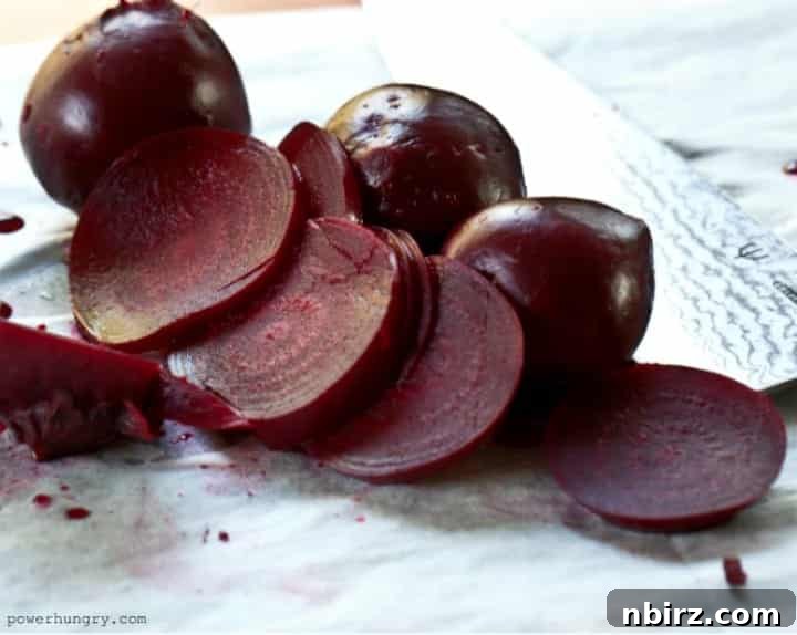 Perfectly roasted beets, some sliced and ready for blending, on a sheet of parchment paper