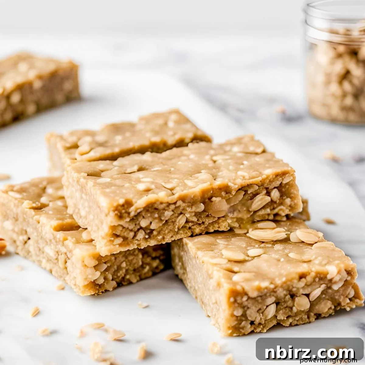 Wholesome Four-Ingredient Vegan No-Bake Cookie Dough Protein Bars 2 Stack of four homemade vegan no-bake cookie dough protein bars on a white marble board, highlighting their chewy texture and wholesome ingredients.