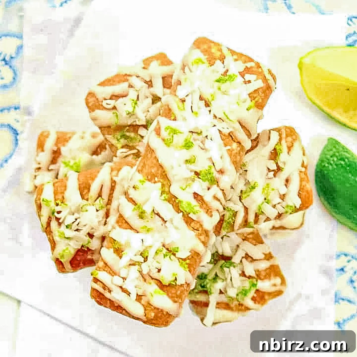 Pure Plant-Powered Coconut Lime Protein Bars 3 A stack of beautifully garnished coconut lime protein bars on a clean surface, emphasizing their artisanal appeal.