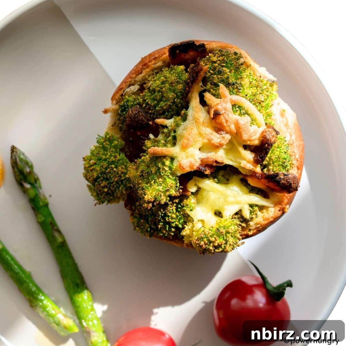 A single perfectly baked vegan chickpea flour broccoli muffin resting on a pristine white plate, showcasing its fluffy texture and golden crust.