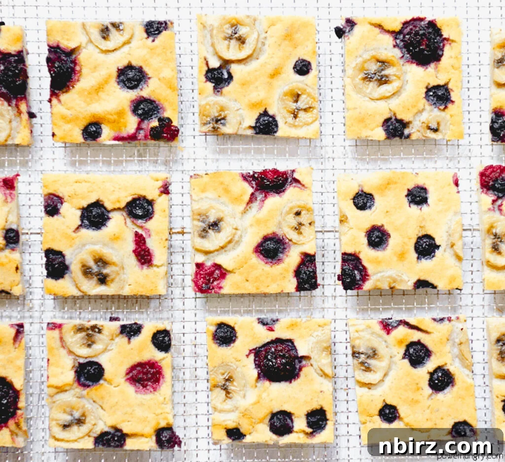 Delicious Vegan Sheet Pan Pancakes Squares of vegan baked pancake with berries on a cooling rack, ready to be enjoyed.