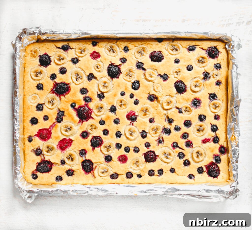 Whole Pan of Baked Vegan Pancakes Overhead shot of an entire pan of golden-brown vegan berry pancakes, fresh from the oven.