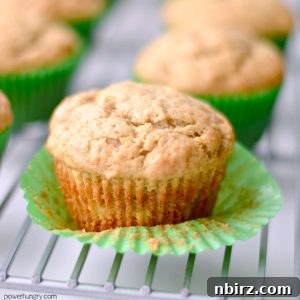 Close-up of a perfectly baked coconut-lime chickpea flour muffin on a white plate