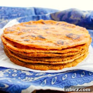 Effortless 3 Ingredient Gluten Free Sweet Potato Tortillas 10 A stack of golden sweet potato tortillas on a blue napkin, ready to be served.