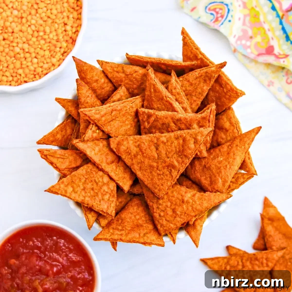Crunchy Zesty High Protein Lentil Chips Vegan Grain Free 8 A large white bowl showcasing a generous portion of freshly baked, crispy lentil chips, ready to be enjoyed.