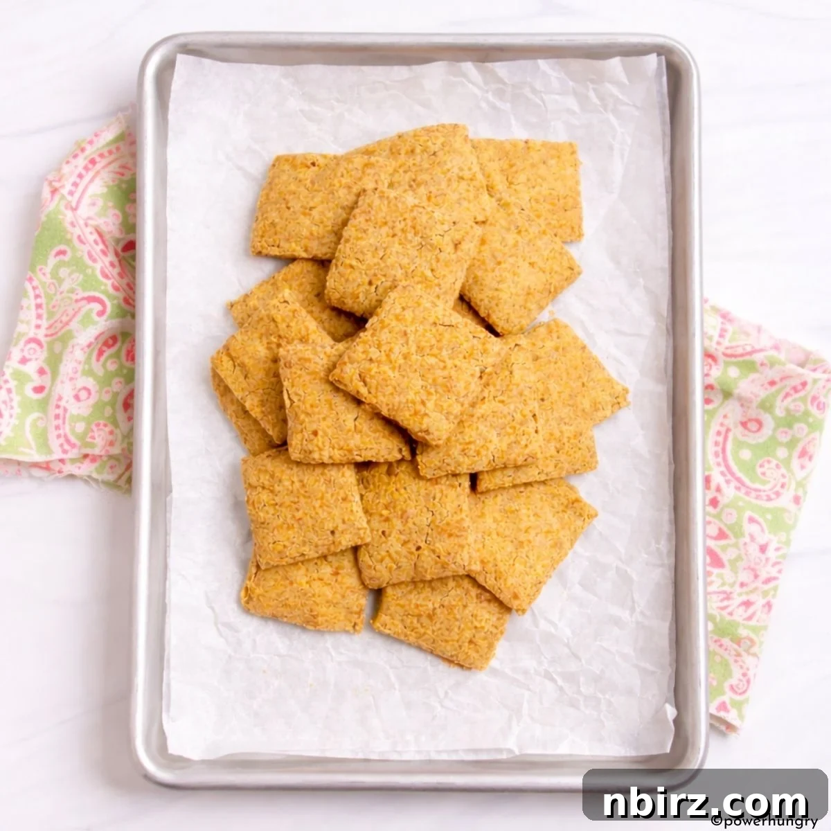 2-ingredient chickpea flour crackers laid out on a baking sheet before being cut and baked again