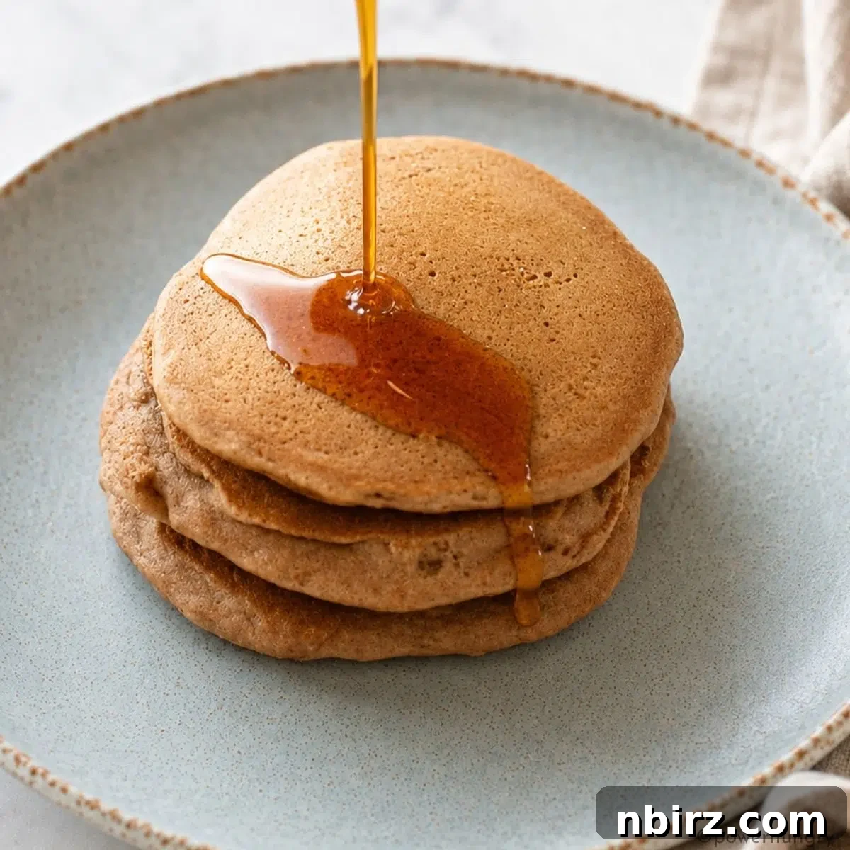 Fluffy Gluten-Free Vegan Buckwheat Pancakes 8 stack of vegan buckwheat pancakes with a drizzle of maple syrup